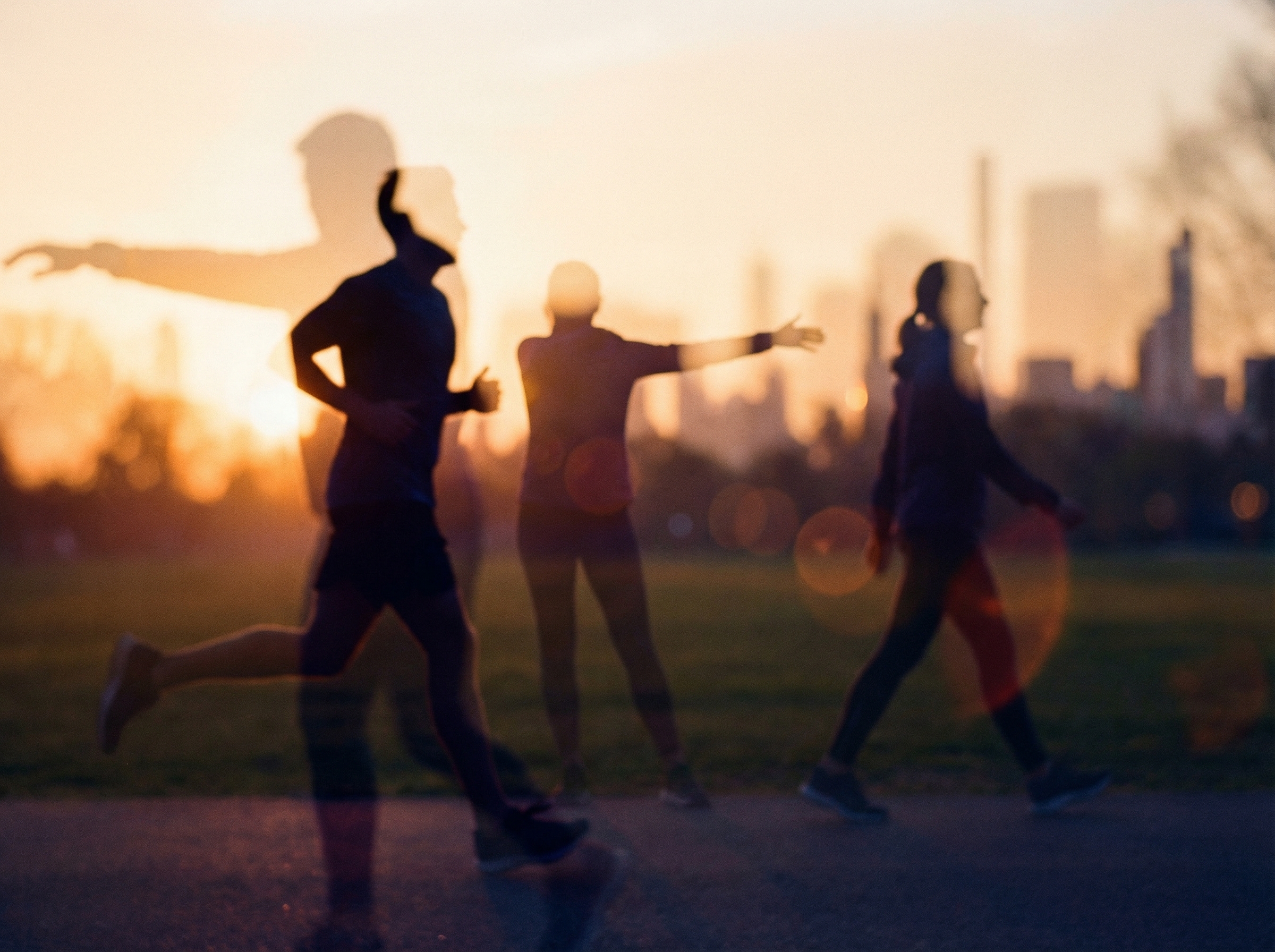 夕暮れにスポーツに取り組む人々のシルエット